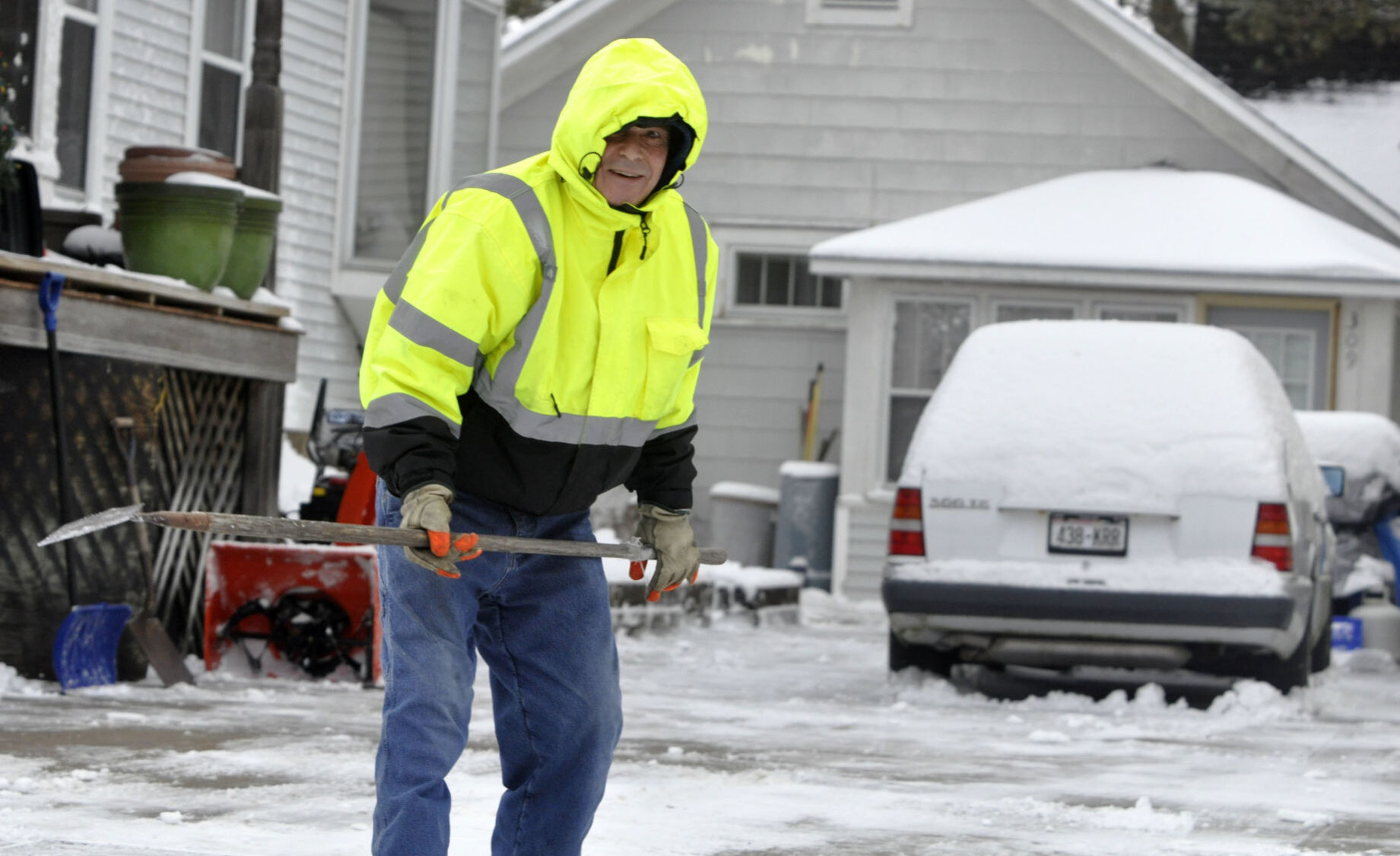 Brain Yunker prepares to scrape some ice off his driveway at his home on Cook Street